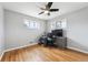 Bedroom with hardwood floors, a ceiling fan, and two windows providing natural light at 7624 Navajo St, Denver, CO 80221
