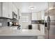 Well-appointed kitchen featuring white cabinets, stainless steel appliances, and a modern backsplash at 7624 Navajo St, Denver, CO 80221