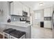 Modern kitchen with white cabinets, quartz countertops, stainless steel appliances, and stylish backsplash at 7624 Navajo St, Denver, CO 80221