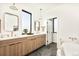 Bright bathroom features double sinks, wood vanity, and a view to outside at 4398 N Pecos St, Denver, CO 80211