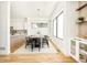 Modern dining area with light wood floors, a designer light fixture, and views into the well-appointed kitchen at 4398 N Pecos St, Denver, CO 80211