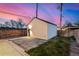 Exterior shot of a garage with modern lighting, adjacent to a paved stone area and a grassy lawn at 4398 N Pecos St, Denver, CO 80211