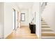 Bright foyer with hardwood floors, modern staircase, and stylish console table under neutral artwork at 4398 N Pecos St, Denver, CO 80211