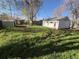 Large backyard featuring lush green grass, mature trees, storage shed, and detached garage at 7810 Pontiac St, Commerce City, CO 80022