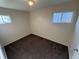 Bedroom featuring neutral walls, brown carpet, and two windows for natural light in this home ready for updates at 7810 Pontiac St, Commerce City, CO 80022