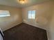 Bedroom featuring neutral walls, brown carpet, and two windows for natural light in this home ready for updates at 7810 Pontiac St, Commerce City, CO 80022