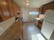 Kitchen with wood cabinets, tile flooring, laminate counters, and white appliances in a home that needs some TLC at 7810 Pontiac St, Commerce City, CO 80022