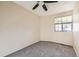 Comfortable bedroom with a ceiling fan, plush carpet, and natural light from a large window at 17949 E Ohio Cir, Aurora, CO 80017