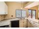 Well lit kitchen area with a double sink, tile counter tops, and access to the patio at 17949 E Ohio Cir, Aurora, CO 80017