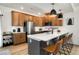 Modern kitchen features wood cabinets, stainless steel appliances, and an island with bar seating at 10149 Xanadu Street, Commerce City, CO 80022