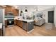 Open floor plan with kitchen and living room, stainless steel appliances, and light wood floors at 10149 Xanadu Street, Commerce City, CO 80022