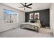 Comfortable primary bedroom with a dark accent wall, modern ceiling fan, and large window at 10149 Xanadu Street, Commerce City, CO 80022