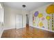 Bedroom featuring hardwood floors, a closet, and painted tree mural at 2703 N Milwaukee St, Denver, CO 80205