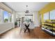 Bright dining room features hardwood floors, modern light fixture, and is open to the updated kitchen at 2703 N Milwaukee St, Denver, CO 80205