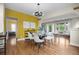 Open dining room with yellow accent wall and modern lighting adjacent to the bright living area at 2703 N Milwaukee St, Denver, CO 80205