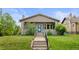 Inviting bungalow with a well-manicured lawn, covered porch, and a cheerful blue front door at 2703 N Milwaukee St, Denver, CO 80205