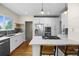 Bright kitchen featuring stainless steel appliances, white cabinets, stone backsplash, and hardwood floors at 2703 N Milwaukee St, Denver, CO 80205