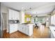 Open concept kitchen with gas range and white cabinets overlooking the dining room at 2703 N Milwaukee St, Denver, CO 80205