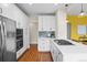 Bright kitchen with stainless steel appliances, white cabinets, and stone backsplash at 2703 N Milwaukee St, Denver, CO 80205