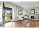 Bright living room featuring hardwood floors, a brick fireplace, and views to the front porch at 2703 N Milwaukee St, Denver, CO 80205