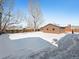 Large backyard with detached garage and snow covered ground at 245 Cedar St, Hudson, CO 80642