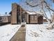 A charming one-story home with wood siding and stone accents, situated on a snow-covered lot at 245 Cedar St, Hudson, CO 80642