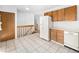 Kitchen features wood cabinets, white appliances, and tile floor at 245 Cedar St, Hudson, CO 80642
