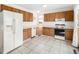 Galley kitchen with wood cabinets and white appliances at 245 Cedar St, Hudson, CO 80642