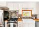 Close up of the kitchen showcasing stainless steel appliances, tile backsplash, and a farmhouse sink under a window at 200 The Lane Rd, Golden, CO 80403