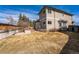 Large backyard featuring a brick fire pit, privacy fence, and mature trees at 15407 E Crestline Pl, Centennial, CO 80015