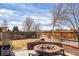 Backyard featuring a brick fire pit surrounded by a wooden fence at 15407 E Crestline Pl, Centennial, CO 80015