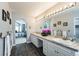 Bright bathroom with dual sinks, spacious counter, decorative flowers, and arched entryway to Primary bedroom at 15407 E Crestline Pl, Centennial, CO 80015