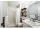 Bright bathroom featuring a shower, vanity, and open shelving for storage at 15407 E Crestline Pl, Centennial, CO 80015