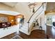 Stunning foyer with curved staircase, chandelier, and views into the living room featuring a decorative fireplace at 15407 E Crestline Pl, Centennial, CO 80015