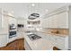 Bright kitchen featuring white cabinetry, a center island with a cooktop, and modern stainless steel appliances at 15407 E Crestline Pl, Centennial, CO 80015