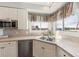 Sunlit kitchen with a stainless steel sink, stainless steel dishwasher, and a scenic view from the window at 15407 E Crestline Pl, Centennial, CO 80015
