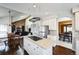 Open kitchen layout with an island cooktop, stainless steel appliances, and a view into the living and dining areas at 15407 E Crestline Pl, Centennial, CO 80015