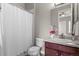 Bright bathroom featuring a shower with curtain, toilet, vanity with sink, and neutral paint at 17358 W 95Th Ave, Arvada, CO 80007