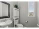 Bathroom featuring a pedestal sink, toilet, cabinet, and a window letting in natural light at 17358 W 95Th Ave, Arvada, CO 80007