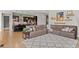 Open-concept living room featuring hardwood floors, a cozy sectional sofa, and direct access to the kitchen at 17358 W 95Th Ave, Arvada, CO 80007