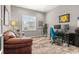 Bright home office space featuring a large window, comfortable seating, and ample desk space at 17358 W 95Th Ave, Arvada, CO 80007