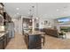 Open-concept kitchen and living area featuring an island, modern appliances, and a cozy living space at 17358 W 95Th Ave, Arvada, CO 80007