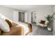 Staged bedroom features a rug, accent chair and a view to the ensuite bathroom at 7543 Eaton St, Arvada, CO 80003