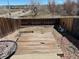 Backyard featuring a wooden deck, gravel, fence, and an ornamental table at 15690 E Mexico Ave, Aurora, CO 80017