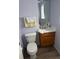 Cozy powder room with a wood vanity, a mirror, and lavender walls at 15690 E Mexico Ave, Aurora, CO 80017