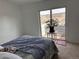 Sunlit bedroom featuring a sliding glass door to a private balcony overlooking neighborhood at 15690 E Mexico Ave, Aurora, CO 80017