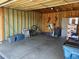 Spacious two-car garage with visible frame construction, storage bins, bikes, and yard tools at 15690 E Mexico Ave, Aurora, CO 80017