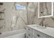 Modern bathroom with marble tiles, white vanity, and bathtub at 104 Stuart St, Denver, CO 80219
