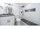 Bright bathroom featuring a white vanity, dark hardware and a modern shower at 1673 S Fulton St, Aurora, CO 80247