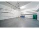 Garage with gray painted floor, storage shelves, and stairs to the doorway at 1673 S Fulton St, Aurora, CO 80247
